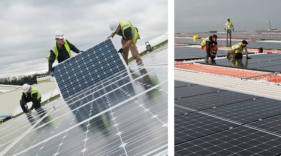 Solar installers fitting solar panels to a commercial rooftop